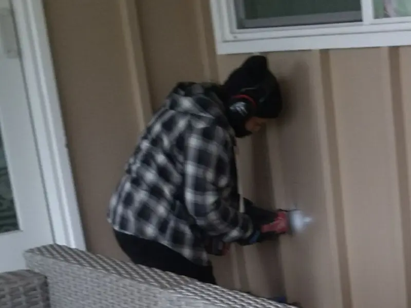 Professional electrician installing an exterior outlet in Halls